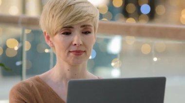 Portre fotoğrafı, sarışın, beyaz, 40 'lı yaşlarda orta yaşlı, yetişkin kadın programcı, dizüstü bilgisayar alışverişi yapan, internet üzerinden internet bankacılığı yapan profesyonel gazeteci.