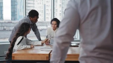 Genç erkek lider ofis kapılarını açıyor. Yönetim kurulunda yeni iş projelerini tartışan iş arkadaşlarıyla buluşurken çok ırklı çalışma grubu çalışanlarına beyin fırtınası yaptırıyor.