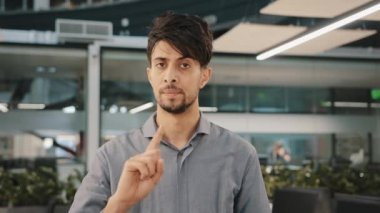 Erkek portresi Arap iş adamı şirketi ofis salonunda baş sallıyor işaret parmağı sallamaktan kaçınıyor. Hiç bir hareket göstermiyor. Yanlış tercihle çelişen şüpheci adam insanları koruma işaretini uyarıyor.