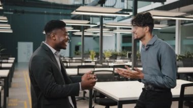 Motivasyonlu Afrikalı Arap iş adamları iş arkadaşları başarı müzakerelerini kutluyor. Faydalı erkek çok ırklı kazananlarla anlaşma sağlanıyor. Zafer dansının keyfini çıkarın.