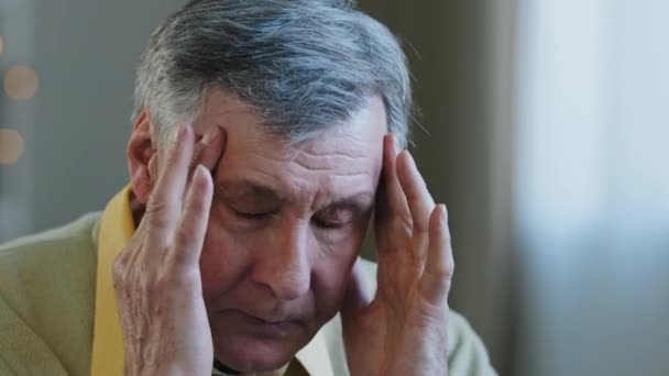 Närbild utmattad frustrerad ansikte äldre man farfar massera näsbro gnugga tempel lider huvudvärk kronisk migrän trött olycklig ohälsosam kaukasiska pensionär känner högt blodtryck — Stockvideo
