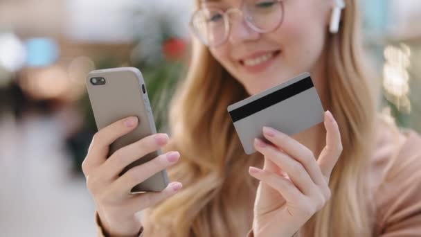 Close-up young girl hands holding smartphone and credit card happy woman customer make online purchase pay bills using banking app on phone virtual remote shopping successful safe transaction concept — Stock Video