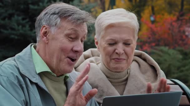 Olumlu yaşlı çift, laptop, yaşlı nesil insanlar ve modern kablosuz teknolojiyi kullanarak video çağrısı yapıyor. Cihazın kolay kullanımı, neşeli olgun aile, çevrimiçi sohbet uzaktan iletişim kavramının keyfini çıkarıyor. — Stok video