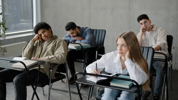 Jóvenes estudiantes empleados trabajadores personal desmotivado sentado en el aula escuchando aburrida conferencia tedioso profesor de entrenador en el seminario corporativo aburrido participantes se duermen sobrecargados de información —  Fotos de Stock