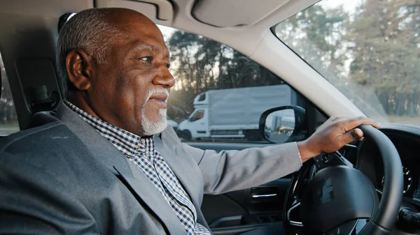 Gammal afrikansk amerikansk glad manlig förare sitter bakom ratten bil leende njuter bekväm rida framgångsrik affärsman köper ny bil provar provkörning jublar i bra köp går på resa — Stockfoto
