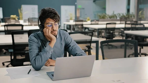 Uttråkad man Arabian man Indiska servicechef i hörlurar har missnöjd look video konferens webinar lära sig språk förbättra själv utbildning yrkeskunskaper studera med svåra uppgift tristess — Stockfoto