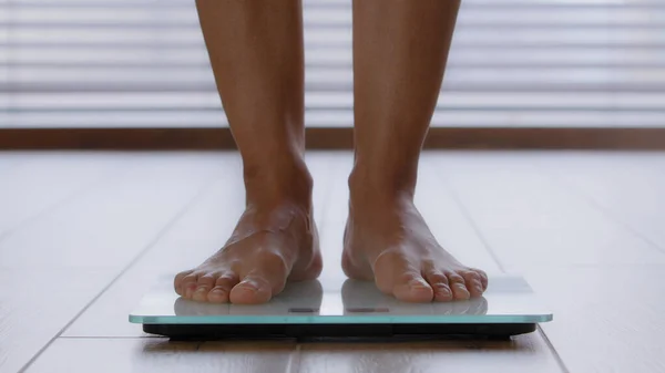 Detailní záběr štíhlé ženské nohy nerozeznatelná žena stojící bosá v koupelně šlápnutí na elektronické váhy kontrola hmotnosti po spalování tuků cvičení doma tělesné kontroly hubnutí dieta životní styl — Stock fotografie