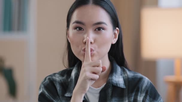 Retrato asiático étnico coreano mujer punto con el dedo cerca de la boca chino japonés chica hace silencio tranquilo gesto mostrando secreto signo pide silencio confidencial secreto información mirando cámara interior — Vídeos de Stock