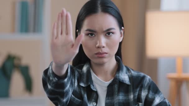 Портрет серьезное разочарование сердитая девушка корейская японская китайская женщина смотрит на камеру, держась за руку запретный жест отказ держать дистанцию стоп жест не знак отказа запрещает ограничение — стоковое видео