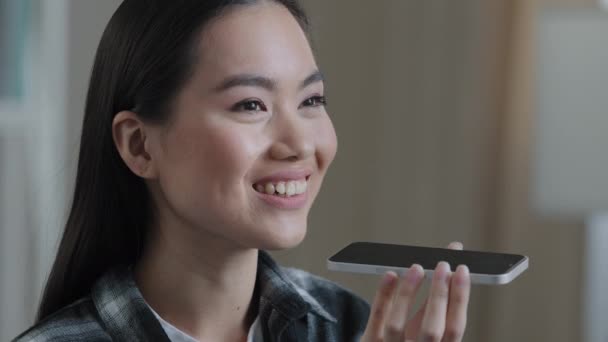 肖像アジアの韓国人女性の女の子は、自宅で音声認識メッセージを記録しますスマートフォンの女性自宅でバーチャルアシスタントアプリセットリマインダーを使用して自宅のオフィスでデジタルAIモバイル支援 — ストック動画