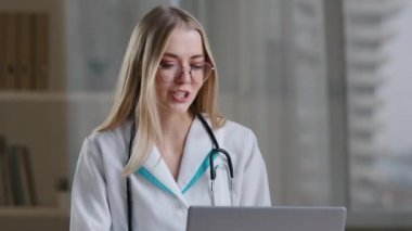 Gözlüklü kadın hemşire, beyaz kadın tıbbi asistanı laptoptan uzak bir hastayı arıyor. Doktor kız terapist sanal bilgisayar uygulaması kullanarak kamerayla konuşuyor. Teletıp sağlık hizmetleri