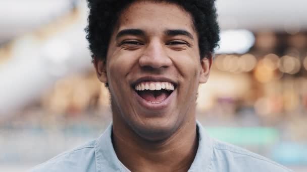 Afrikansk amerikansk 30 'erne mand ser på kameraet har bred oprigtig toothy smil dental koncept griner fyr vlogger optagelse filme nye vlog indendørs sjove oplysninger grine glæde joke hoved skudt portræt – Stock-video