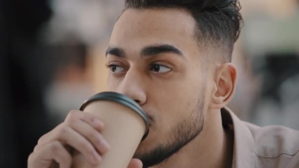 Primo piano ritratto di felice giovane barbuto ragazzo arabo sorridente uomo positivo bere caffè da tazza di carta godendo fine settimana di successo uomo d'affari ispanico pensieroso guardando intorno a riposo nel tempo libero — Video Stock