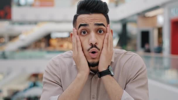 Yaklaş genç Arap şaşırmış adam iyi bir teklif aldı mutlu İspanyol erkek piyango kazandı inanılmaz haber portresi heyecan verici Hint milenyum çocuğu mutluluğu sarstı yanaklarına dokunarak — Stok video