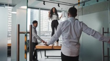 Arkadan bakan lider ofis patronuna kapıyı açarken çok ırklı çalışanları gafil avladı. Korkmuş işçiler görevlerine başladılar. İspanyol kız uluslararası meslektaşlarıyla ateşli bir şekilde masada dans ediyor.