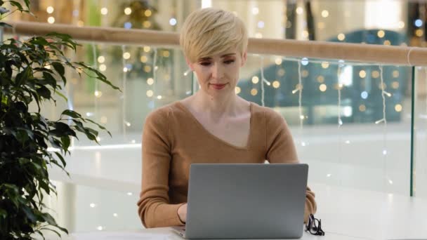 白人ビジネス女性大人40代マネージャーフリーランスノートパソコンを使用して無料のwifi入力作業オンラインネット親指を示すアップジェスチャーコンピュータアプリの広告推薦サイトサービスに満足 — ストック動画