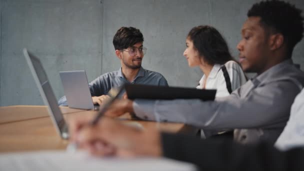 Deux collègues divers bavardant amicalement distrait de remue-méninges employés multiraciaux dans les tâches de travail au premier plan utilisent un ordinateur portable flou main méconnaissable prendre des notes projet de travail d'équipe de routine de bureau — Video