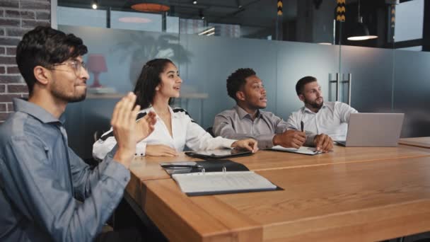 Karyawan multietnis muda yang bahagia duduk di kantor mendengarkan pelatihan beragam orang-orang bisnis bertepuk tangan untuk seminar bertepuk tangan di presentasi konsep keberhasilan prestasi perusahaan — Stok Video