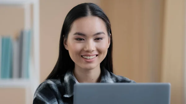 Porträtt asiatisk leende nöjd flicka användare student frilansare köpare bloggare affärskvinna 20s dam tittar på bärbar skärm uppriktigt leende med hjälp av datorprogram tjänst webbplats chatta bläddra — Stockfoto