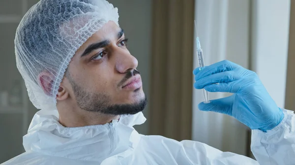 Fiatal arab férfi spanyol orvos orvos sebész speciális orvosi védő egyenruha visel gumikesztyűt tartja fecskendő gyógyszer vakcina injekció covid-19 anti-coronavirus gyógyszer jogorvoslat — Stock Fotó