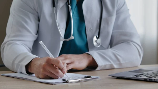 Steteskop dolduran nitelikli erkek terapist hasta erkek doktor için reçeteli ilaçların detaylı dozunu yazan genç pratisyen hekimin reçete yazdığını bildiriyor.