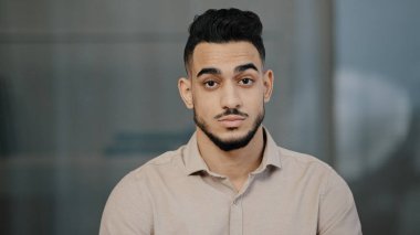 Ciddi Arap işçi girişimci başını iki gözünü işaret ederek gösteriyor ki sen işaret ediyorsun İspanyol asıllı iş adamını uyaran iş arkadaşı güvensizliğini gösteriyor.