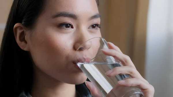 Close up asian woman drinking clean water home delivery holding glass lunch morning daily ritual good habit girl feels thirsty health care hydration dehydration refreshment drink smiling feeling good — Stock Photo, Image