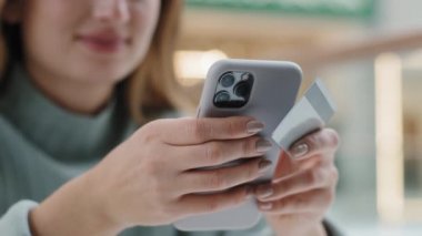Telefon ve kredi kartı tutan kadınların ellerini kapat. Bilinmeyen kadın internet sitesi uygulaması için sipariş veriyor. Cep telefonunu kullanarak mal alım-satımı için ödemeyi akıllı telefon ile yapıyor.