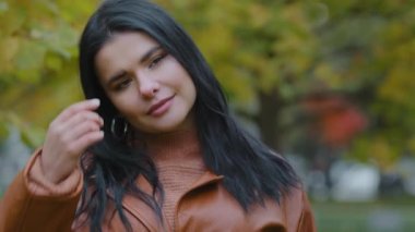 Yakın plan, genç, çekici, zarif, düşünceli bir kadın. Sonbahar parkında portrede dikiliyor. İspanyol kız modeli poz veriyor.