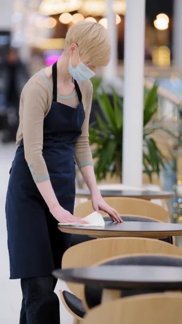 Kaukaska kobieta w średnim wieku kelnerka barista za pomocą ręcznika zamiatania tabeli w kawiarni dezynfektor stołówki przed otwarciem restauracji kobieta dorosłych właścicielka kawiarni sprzątanie biurko do obsługi klienta — Wideo stockowe