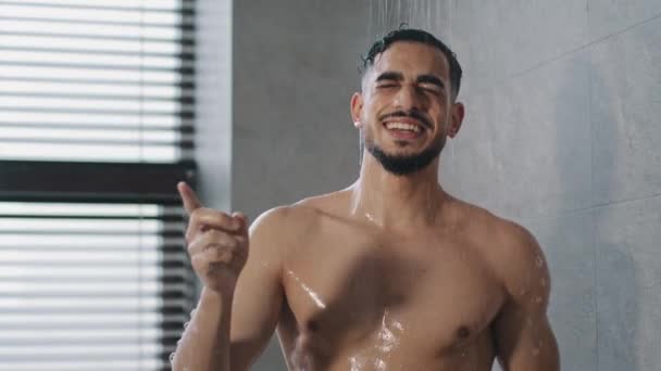 Boldog boldog gondtalan indiai arab srác meztelen férfi énekel dalt a zuhany alatt táncolva a fürdőszobában vicces reggeli higiénia. Vicces szexi férfi zenét hallgat énekel mozog tánc mosás a fürdőben — Stock videók