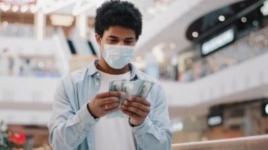 Koruyucu maskeli Afrikalı adam, maskeli hasta para sayıyor. Para sayıyor. Para, para, para krizleri, Coronavirus salgını.