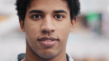 Gülümseyen Afrikalı bin yıllık profesyonel bir adam dişlek bir gülümsemeyle kameraya bakıyor. İçeride poz veren kendine güvenen girişimci öğrenci lideri adam. Pozitif erkek portresi.