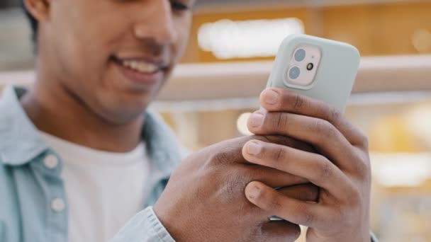 Uśmiechnięty, nierozpoznawalny biznesmen w domu czytający wiadomości telefoniczne pobierający aplikację telefon komórkowy nieznany szczęśliwy african american guy wpisujący na czacie sms-y randki online z dziewczyną w sieci — Wideo stockowe