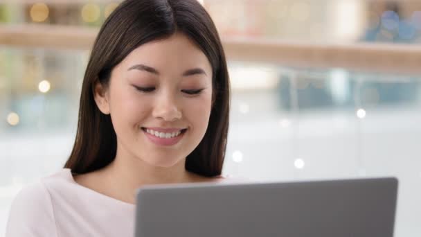 ポートレート笑顔幸せなアジアの女性の顔はラップトップで見て満足した女の子の女性フリーランスの上司の労働者マネージャーは、ウェブサイトの閲覧ネット上でビデオをオンラインで見てショッピングアプリサービスを使用してコンピュータを入力 — ストック動画