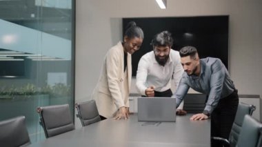 Dizüstü bilgisayara bakan heyecanlı mutlu iş adamları grubu şirket başarısını kutluyor. Harika takım çalışması hedefleri okunuyor. İnternet üzerinden e-posta gönderiliyor.