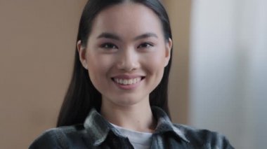 Mükemmel ciltli, doğal görünümlü, samimi bir gülümsemeyle kameraya bakan yakın plan kadın yüzü. 20 'li yaşlarda Asyalı bir kadının portresi Koreli bayan sevgili eş öğrenci model dişlek, sırıtan bir müşteri