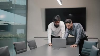 İki erkek Arap işçi yöneticisi, programcı iş adamı dizüstü bilgisayara bakıyor bağlantı sorunları olduğunu düşünüyor Afrikalı patron, kadın iş kadını koçu takım çalışmasına yardım ediyor.