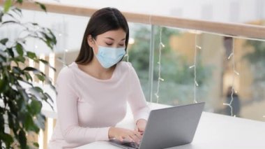 Asyalı kız öğrenci, bilgisayarlı, kahve dükkanında iş kadını tıbbi koruma maskesi takan, uzaktan yakından Coronavirus salgınında çalışan online ödeme danışmanlığı yapan müşteriler.