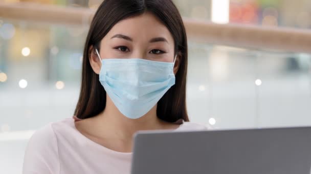 Азиатская корейская успешная деловая женщина работница фрилансер студентка-дизайнер специалист по лицевой медицинской маске с ноутбуком глядя в камеру показывая большой палец вверх рекомендует WiFi компьютерное приложение — стоковое видео