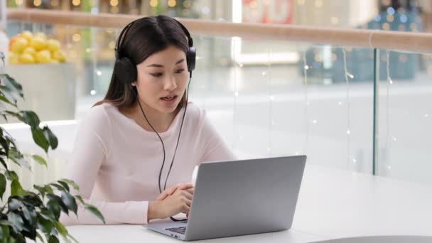 Asiática mujer trabajador gerente mujer coreana agente ayuda línea consultora chica en micrófono de auriculares en la oficina café mesa e-learning en línea mentor profesor de negocios estudiar hablar soporte operador de servicio — Vídeos de Stock