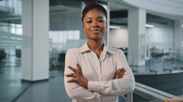 Африканский тысячелетие 30-х годов успешный уверенно сильная деловая женщина феминизм работница босс женщина-лидер многорасовая женщина в формальной рубашке, позируя скрещивая руки глядя в камеру в офисе корпорации — стоковое видео