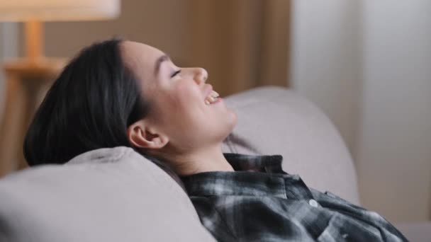 Cabeça tiro vista lateral esgotado feliz asiático etnia mulher caindo no aconchegante sofá em casa dormindo descansando duro trabalho dia escolher sofá em móveis loja testes suavidade conforto aliviar o estresse — Vídeo de Stock