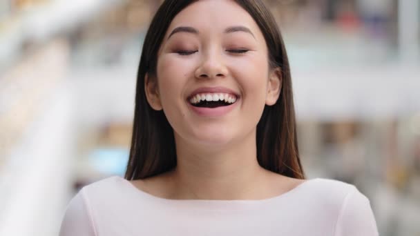 陽気な幸せな面白い女性の顔アジアのデントガールモデル笑い感情冗談満足カメラを見て楽しいユーモアのセンス楽しい雰囲気の女性が楽しい気楽な気分を持っている — ストック動画