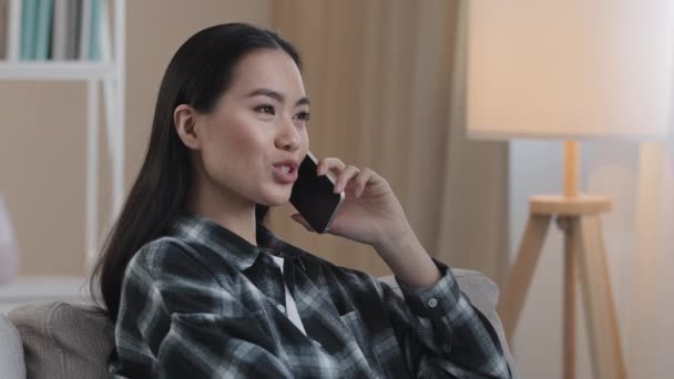 Ázsiai koreai japán kínai lány Millennial nő barátságos távoli beszél mobiltelefon mobiltelefon csevegés beszél barátja család beszél otthon közelkép női arc válaszol hívás — Stock videók
