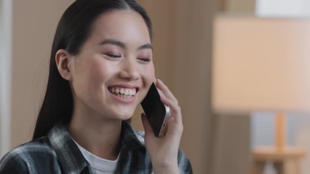 Азиатская девушка отвечает на телефонный звонок болтая с друзьями, звоня на мобильный телефон смеясь улыбаясь дружеский разговор удаленный чат портрет тысячелетней корейской леди заказа со смартфоном — стоковое видео