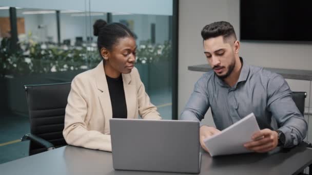 African female financial advisor businesswoman agent lawyer insurer colleague partner discuss project papers documents report with arab indian male explaining contract negotiating agreement consulting Stock Footage