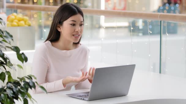 Angry asian frustrated female corporate enterpreneur worker freelancer woman shouting at office cafe table colleagues quarrel online video conference answer no misunderstanding dissatisfied customer — Stock Video