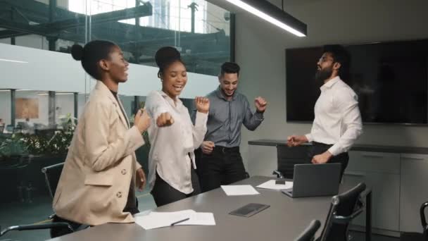 Мотивована багаторасова різноманітна бізнес-група успішна команда, яка танцює, святкуючи успіх в офісі, щаслива запропонувати зарплатню п'ятничним працівникам, які розважаються разом, насолоджуючись перемогою танцювального тріумфу — стокове відео
