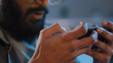 Kapanış detaylarını erkek eller karanlıkta evde tanınmaz halde sakallı adam mobil online oyun oynuyor internet spor yarışması yapıyor akıllı telefon zafer ödülü kazanıyor